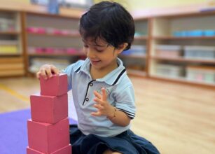 Child building pink tower at Starshine Montessori