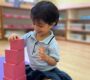 Child building pink tower at Starshine Montessori 90x80