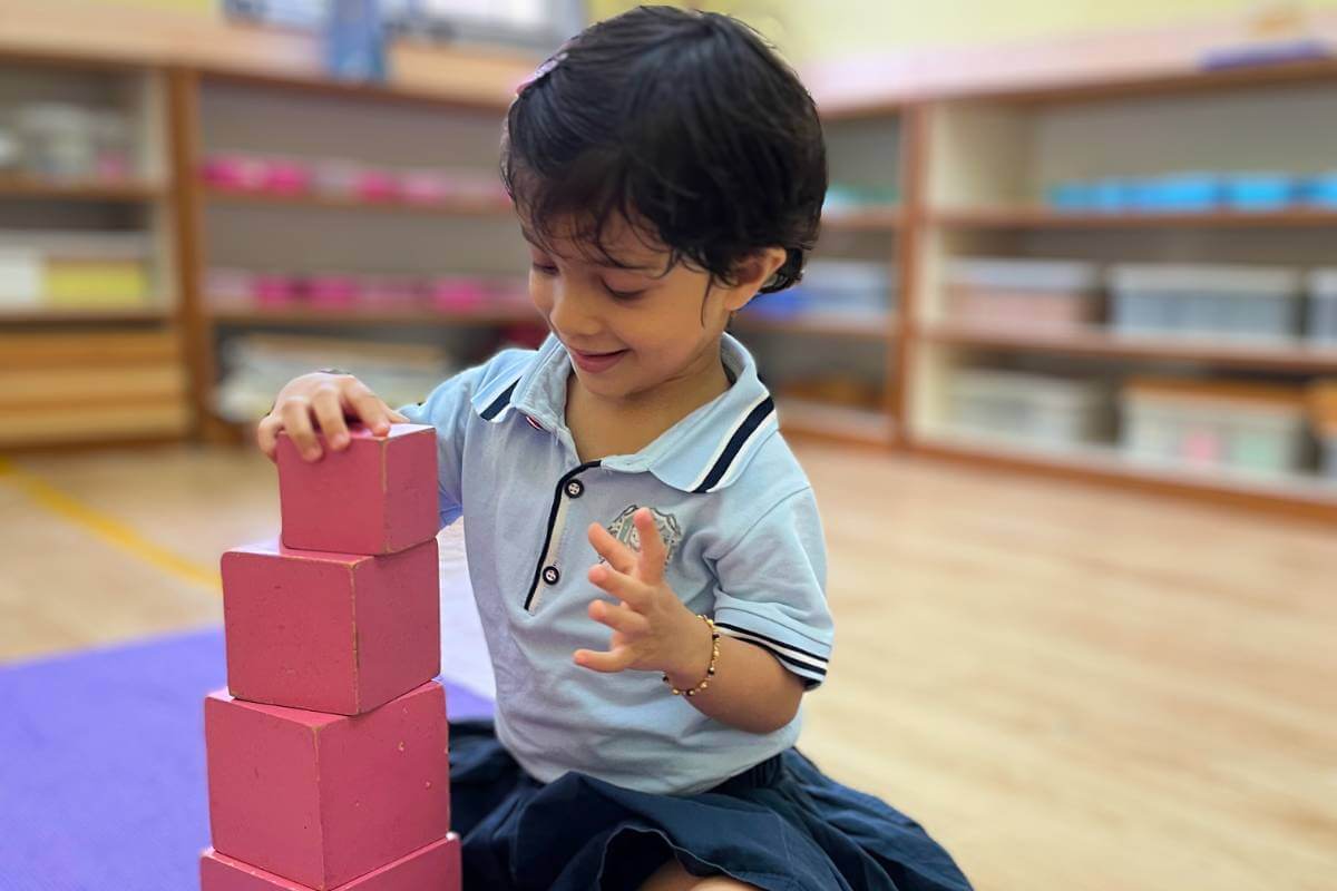 Child building pink tower at Starshine Montessori