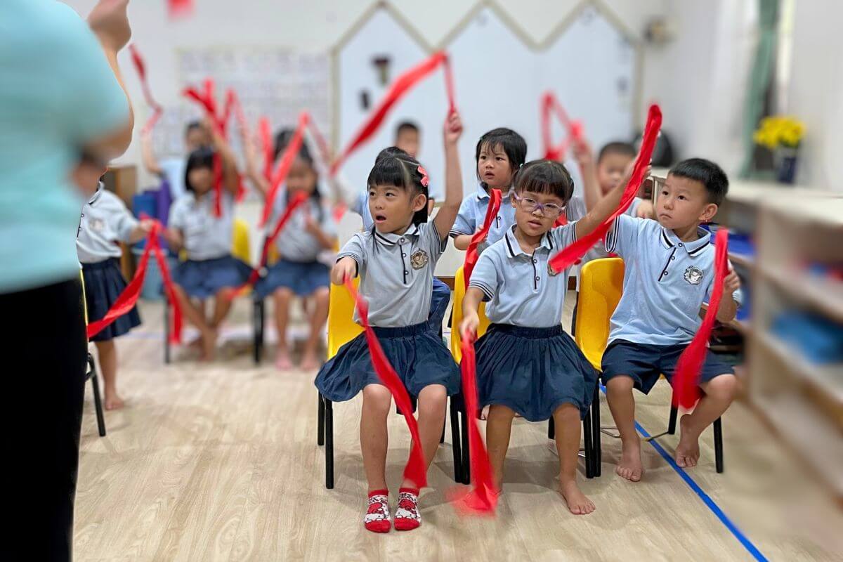 Children at Starshine Montessori performing a ribbon dance, fostering coordination and teamwork