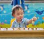 Toddler playing with a wooden toy to enhance cognitive skills Starshine Montessori 90x80