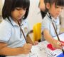 Children at Starshine Montessori in Singapore practicing Chinese calligraphy in a classroom setting 90x80