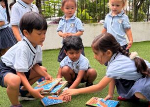 Group of young children working together on a puzzle during an outdoor learning activity at Starshine Montessori preschool, enhancing teamwork and collaboration skills.