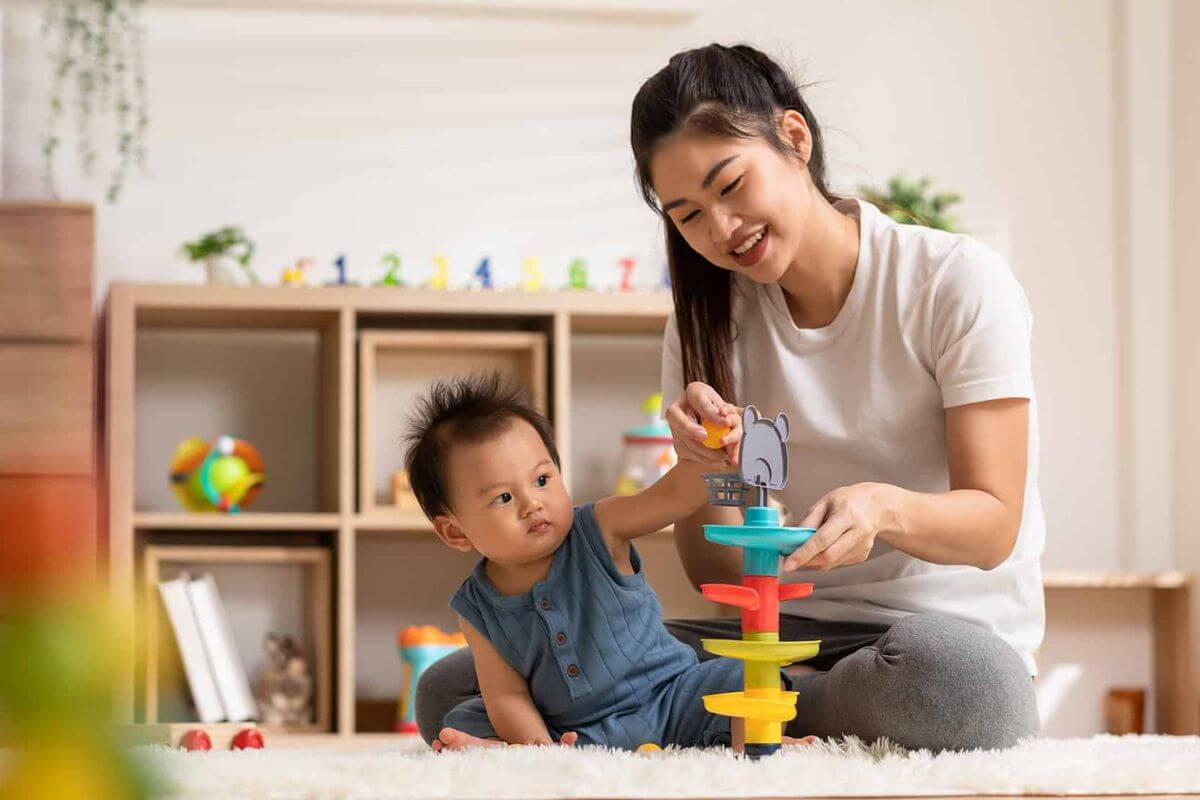 Baby enjoying early learning playtime with colourful toys, fostering child development through interactive activities in Singapore.