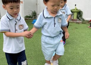 Young children holding hands during an outdoor preschool activity, fostering teamwork, support, and social development at Starshine Montessori.