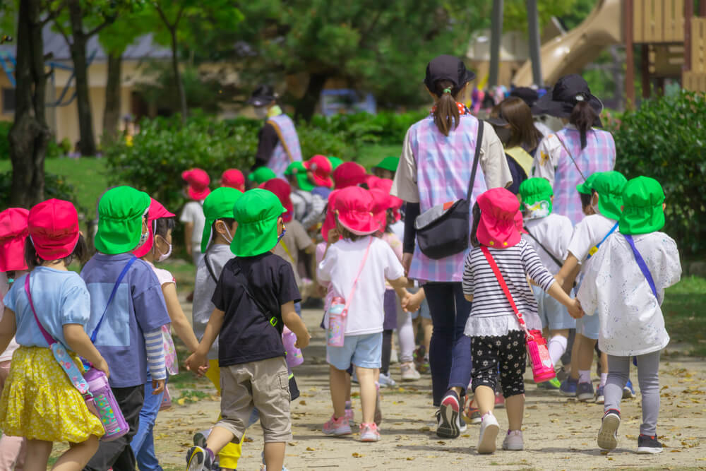 Group of preschool children on an outdoor field trip, exploring nature and learning through hands-on experiences in a fun group activity.