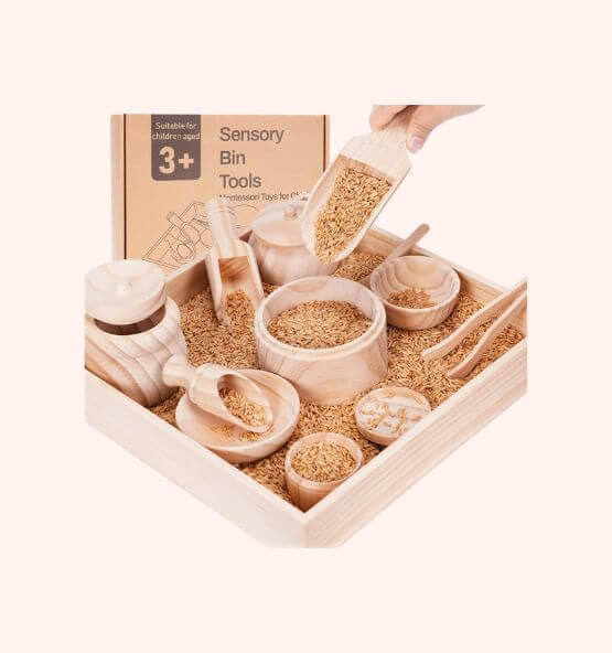 A wooden sensory bin tools set, including scoops, bowls, and utensils filled with grains, designed for children aged 3 and above.