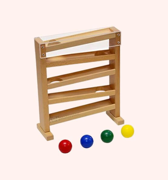 A Montessori wooden ball tracker toy featuring a four-level ramp structure with a clear top panel. The set includes four colorful balls (red, blue, green, and yellow) designed to roll down the ramps, enhancing visual tracking, hand-eye coordination, and cause-and-effect learning for young children.